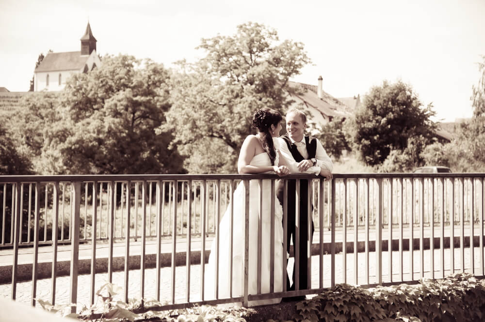 Für das Brautpaarshooting steht das Hochzeitspaar auf einer Brücke.